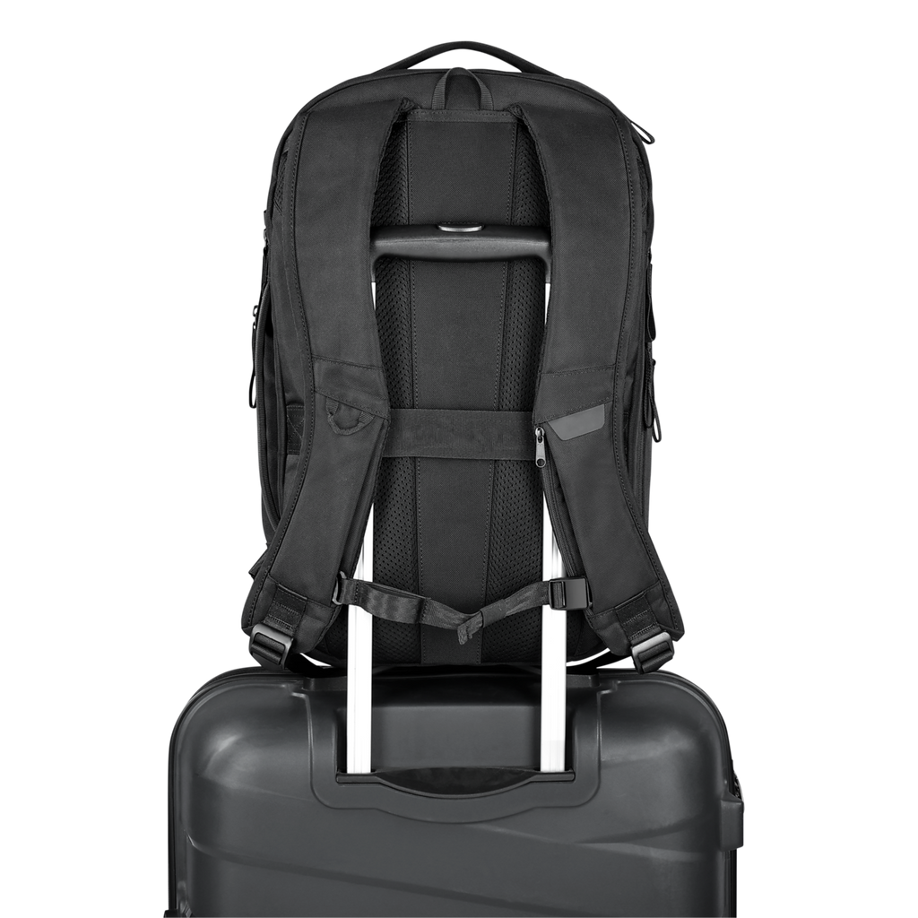 Black backpack on top of a black suitcase with a white background