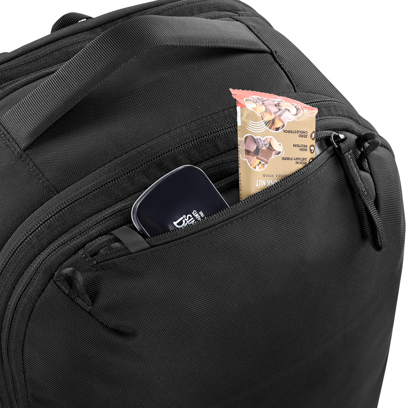 Black backpack with a small pocket open, revealing a phone and snack package.